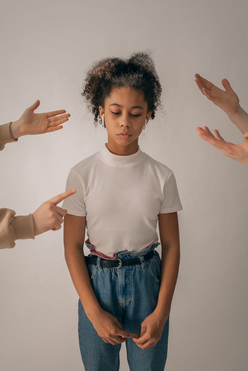 unrecognizable people punishing sad black girl