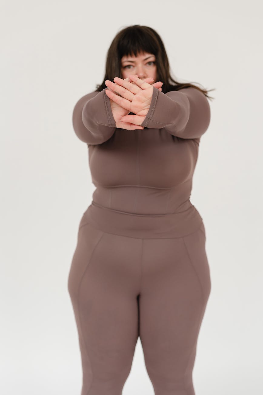 overweight woman showing stop gesture in studio